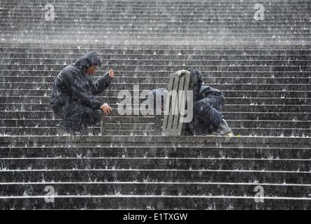 Beijing, Chine. 10 Juin, 2014. Les travailleurs tentent de draguer les égouts étouffé dans la pluie à l'extérieur du National Centre for the Performing Arts (NCPA) à Beijing, capitale de Chine, le 10 juin 2014. Une pluie torrentielle a frappé la capitale mardi après-midi. Credit : Luo Xiaoguang/Xinhua/Alamy Live News Banque D'Images