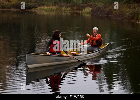 Middle-aged couple paddling canoe dans cadre paisible sur le lac Oxtongue, Muskoka, Ontario, Canada. Banque D'Images