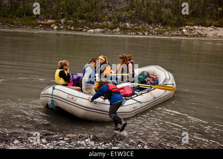 Jeune fille pousse de radeau sur la rive de la rivière Nahanni, la réserve de parc national Nahanni, Territoires du Nord-Ouest, préserver le Canada. Banque D'Images