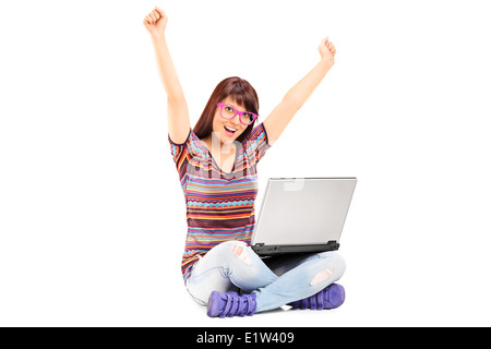 Woman working on laptop et gesticulant succès Banque D'Images