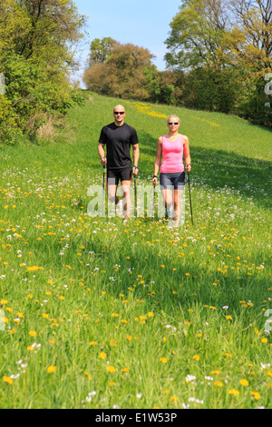 Un couple marche nordique grâce à la formation du paysage rural Banque D'Images