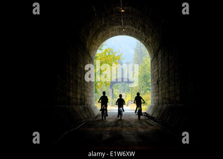 Les jeunes garçons à prendre leur vélo à travers le tunnel de Princeton sur le sentier KVR dans la région de Similkameen de la Colombie-Britannique, Canada Banque D'Images
