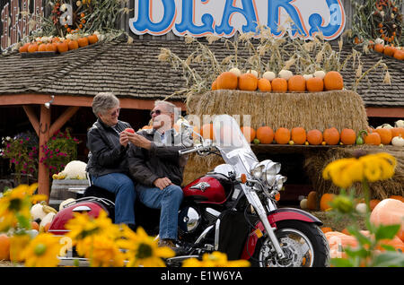 Moto couple s'arrête à un stand de fruits à Keremeos dans la région de Similkameen de la Colombie-Britannique, Canada Banque D'Images