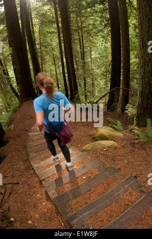 Femme trail running sur le Pacific Trail, Capilano Capilano River Regional Park, North Vancouver, Colombie-Britannique, Canada Banque D'Images