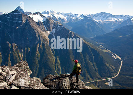 Un jeune homme d'escalade l'arête ouest du mont Tupper, Roger's Pass, le parc national des Glaciers, C.-B. Banque D'Images