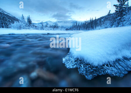 L'aube sur un couvert de glace un rocher situé dans la Wheaton River qui est près de Whitehorse, au Yukon. Banque D'Images