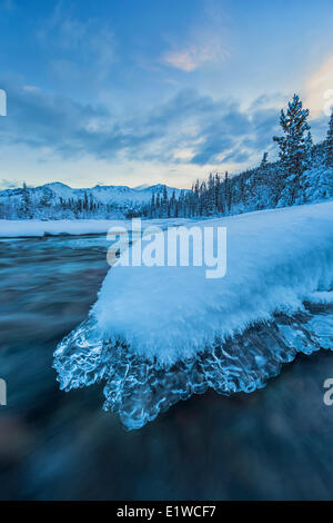 L'aube sur un couvert de glace un rocher situé dans la Wheaton River qui est près de Whitehorse, au Yukon. Banque D'Images