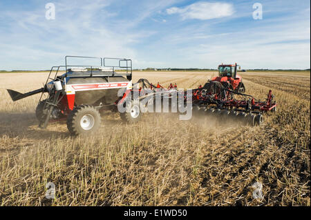 Déplacer le tracteur et l'air et jusqu'à la plantation semoir blé d'hiver dans un champ de chaume de canola jusqu'à zéro, Lorette, Manitoba, Canada Banque D'Images