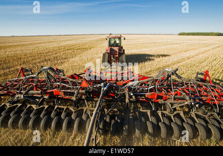 Déplacer le tracteur et l'air et jusqu'à la plantation semoir blé d'hiver dans un champ de chaume de canola jusqu'à zéro, Lorette, Manitoba, Canada Banque D'Images