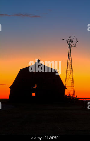 Lever du soleil sur la vieille grange cour avec moulin à vent. Carsland, Alberta, Canaada Banque D'Images