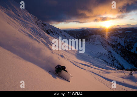 Un skieur femelle tourner dans le alpenglow ci-dessous Ymir pic dans la arrière-pays d'eau vive près de Nelson, Colombie-Britannique Banque D'Images