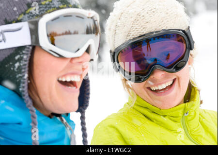 Deux jeunes femmes rient tandis que sur un voyage de ski dans les montagnes Monashee, Colombie-Britannique Banque D'Images