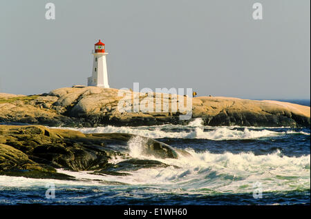 Déferlement des vagues sur la côte, avec le phare de Peggy's Cove en arrière-plan, Peggy's Cove, en Nouvelle-Écosse, Canada, Banque D'Images