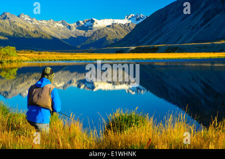 Un homme pêche de mouche sur le rivage, Tarn, Horseshoe Valley Ahuriri, Nouvelle-Zélande Banque D'Images