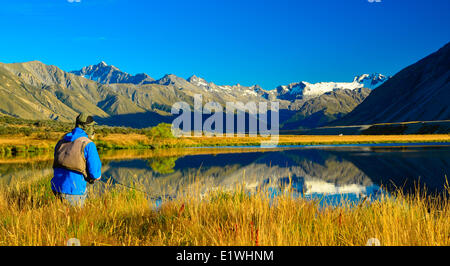 Un homme pêche de mouche sur le rivage, Tarn, Horseshoe Valley Ahuriri, Nouvelle-Zélande Banque D'Images