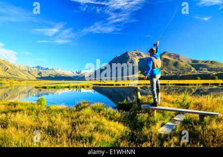 Un homme pêche de mouche sur le rivage, Tarn, Horseshoe Valley Ahuriri, Nouvelle-Zélande Banque D'Images