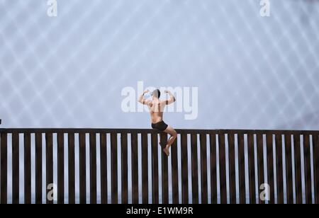 San Diego, Californie, USA. 8 juin 2014.Un nageur du Mexique pose au sommet de la clôture séparant les États-Unis et le Mexique au parc de l'amitié sur la frontière du parc d'État sur le terrain. Le parc est le plus southwesten partie des États-Unis. © ZUMA Press, Inc./Alamy Live News Banque D'Images