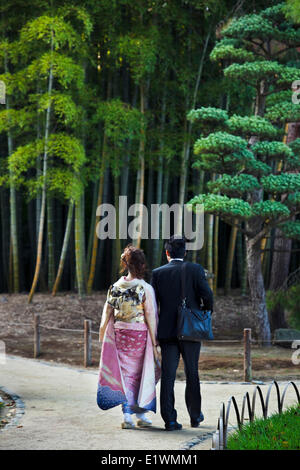 Couple strolling près d'un bosquet du bambou dans le Jardin Korakuen à Okayama. La femme porte un kimono furisode qui traduit comme ' Banque D'Images