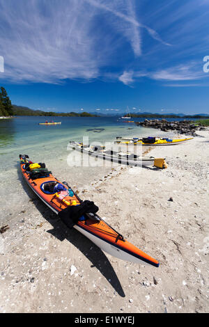 Ligne de kayaks une plage de sable blanc sur l'île de la Main situé à l'intérieur de l'île brisée Barkley Sound groupe britannique de l'île de Vancouver Banque D'Images