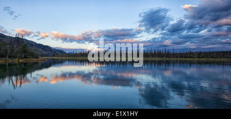 La fin de l'été le ciel et les nuages reflètent sur Marsh Lake, au Yukon. Banque D'Images