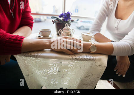 Portrait couple holding hands in cafe Banque D'Images