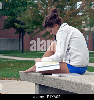 Une femme, son livre à l'extérieur, sur le campus de l'Université de Wisconsin - Milwaukee. Banque D'Images