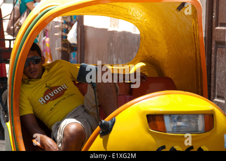 Coco chauffeur de taxi dormant dans son taxi jaune de coco à la Havane, Cuba. Banque D'Images