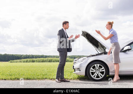 Vue latérale sur toute la longueur du couple d'affaires plus de casse voiture à la campagne Banque D'Images