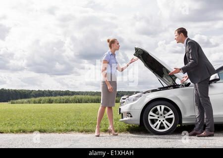 Toute la longueur du couple d'affaires par la rupture de voiture à la campagne Banque D'Images