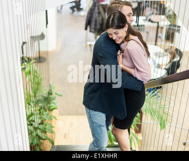 Vue latérale d'affaires jeune couple hugging on staircase Banque D'Images