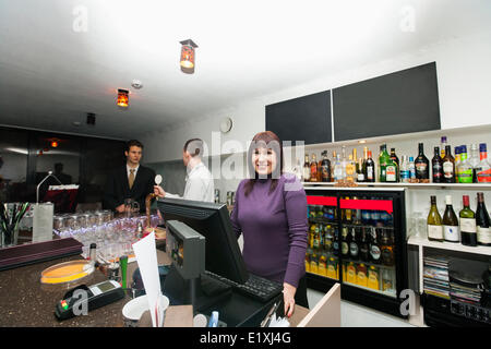 Portrait of female cashier avec manager et le barman au comptoir du bar Banque D'Images