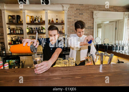 Les barmans working at counter in restaurant Banque D'Images