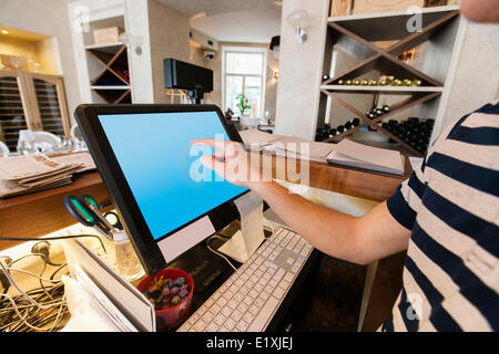 Image recadrée de caissier de toucher l'écran d'ordinateur au restaurant counter Banque D'Images