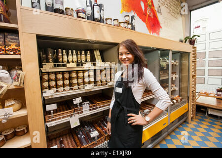 Portrait of confident saleswoman standing in supermarket Banque D'Images