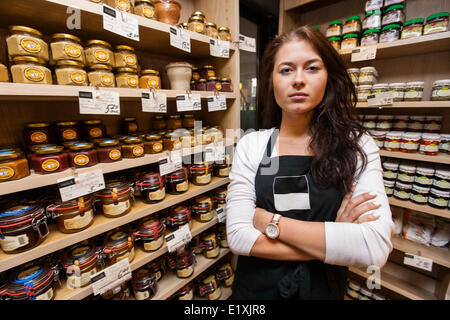 Portrait of confident saleswoman standing in grocery store Banque D'Images