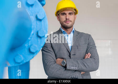 Portrait of young male architect standing les bras croisés dans l'industrie Banque D'Images