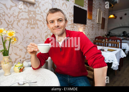 Portrait of happy young man holding Coffee cup at cafe Banque D'Images