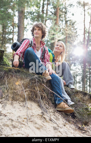 Toute la longueur de la randonnée couple assis sur le bord de la falaise en forêt Banque D'Images