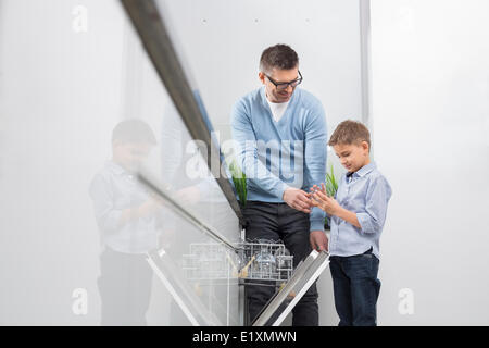 Père et fils en verre cuisine au lave-vaisselle Banque D'Images