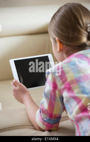 Vue arrière du girl using tablet PC at home Vue arrière du girl using tablet PC at home