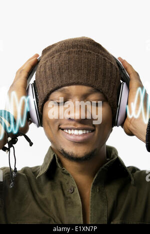 Heureux jeune homme profiter de la musique au casque sur fond blanc Banque D'Images