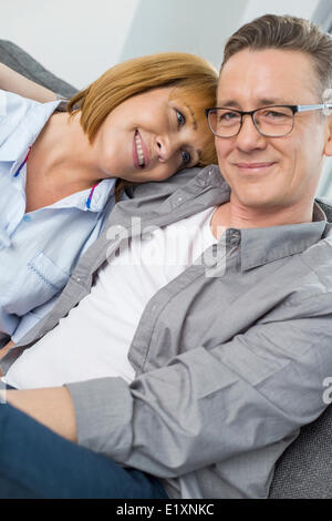 Portrait of smiling man sitting with woman at home Banque D'Images