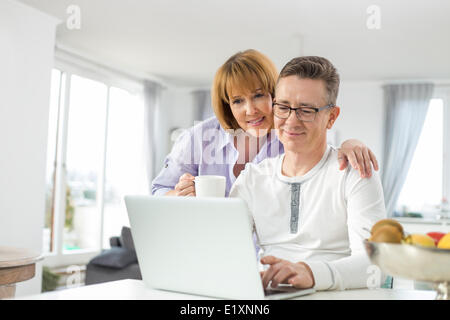 Couple aimant using laptop together at home Banque D'Images