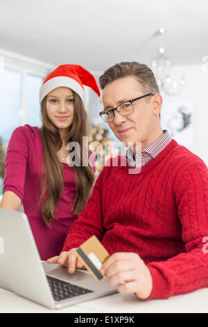 Portrait de père et fille shopping en ligne durant les fêtes de Noël Banque D'Images