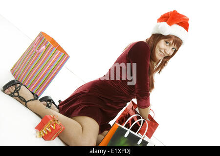 La jeune fille dans un bouchon avec les achats de Noël Banque D'Images