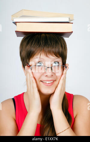 Girl à lunettes avec books on head Banque D'Images