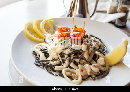 Spaghetti noir avec des fruits de mer sur plaque blanche Banque D'Images