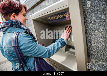 Une jeune femme female college university student retirer de l'argent au distributeur automatique distributeur UK Banque D'Images