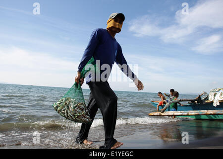 11 juin 2014 - Tacloban, Philippines - Tacloban, Philippines - Un pêcheur se rince ses prises en mer à Tacloban City le 11 juin 2014. Le 8 novembre 2013, Haiyan, l'un des plus puissant typhon à jamais frappé la terre, ravagé les Visayas orientales des milliers de morts et de sans-abri. Le gouvernement estime à 16 millions de personnes ont été touchées par le typhon, avec 6 300 morts et des milliers d'autres portés disparus. Logement et subsistance sont parmi les graves défis dans le processus de réadaptation dans les régions touchées par Haiyan sept mois après la catastrophe. (Crédit Image : © Mark Cristino/NurPhoto ZUMAPR / Banque D'Images