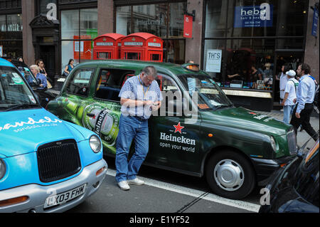 Un chauffeur de taxi vérifie son téléphone après le blocage du Strand à Londres, en Angleterre, au cours d'un chauffeur de taxi protester contre le téléphone mobile app Uber. Banque D'Images